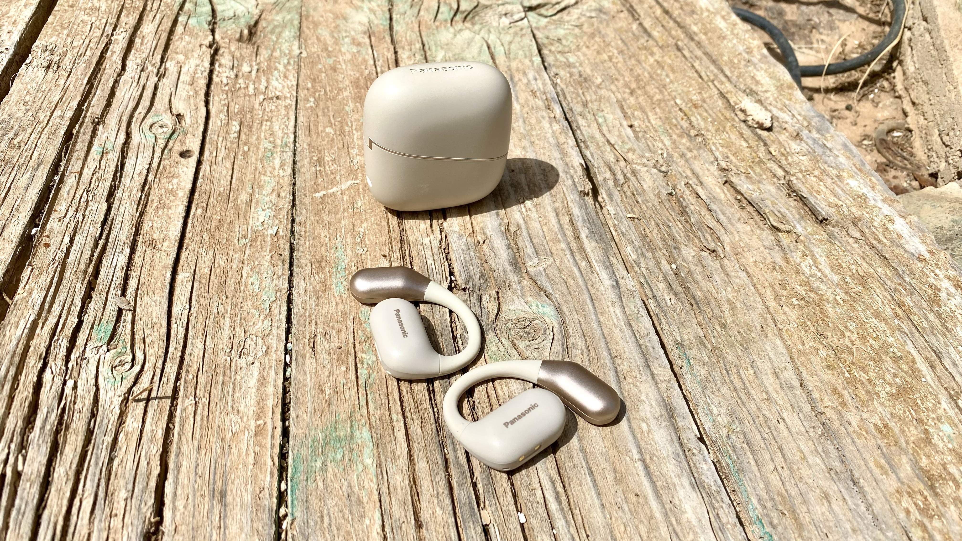 Panasonic RB-F10 open earbuds and charging case on a wooden surface
