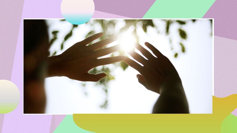 image of woman cupping hands in front of the sun