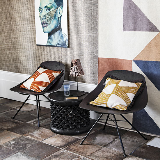 living room with wall painting chair and cushions with round table and wooden tiles on flooring