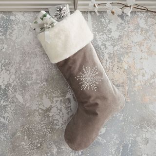grey coloured christmas stocking with white flower