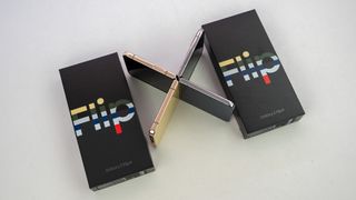 Samsung Galaxy Z Flip 4 Bespoke Edition in gold and navy blue colors in an X formation with their boxes