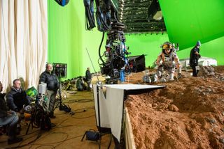 Mars On A Soundstage? Or a soundstage on Mars? Actor Matt Damon concentrates on lonliness while surrounded by many film crew members.