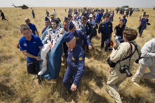 The space station's Expedition 31 crew is moved to medical tent after landing.