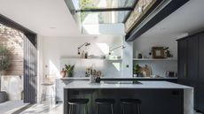 modern white kitchen extension with glass roof light and sliding doors