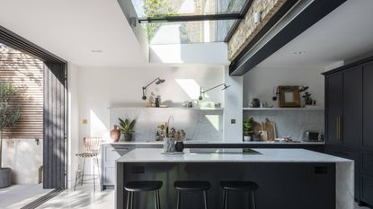 modern white kitchen extension with glass roof light and sliding doors