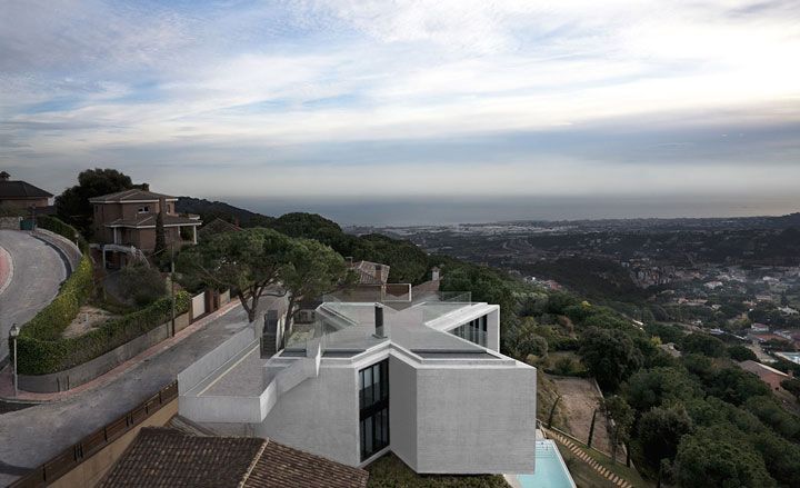 The X-House sits atop a steep hill in Cabrils, Barcelona, with impressive views over a valley.