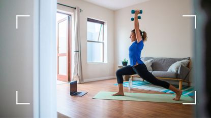 Woman holding dumbbells above her head, doing yoga as a workout