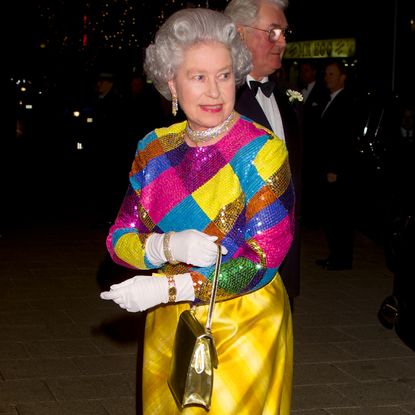 Queen Elizabeth wearing a colorful sequined gown and smiling 