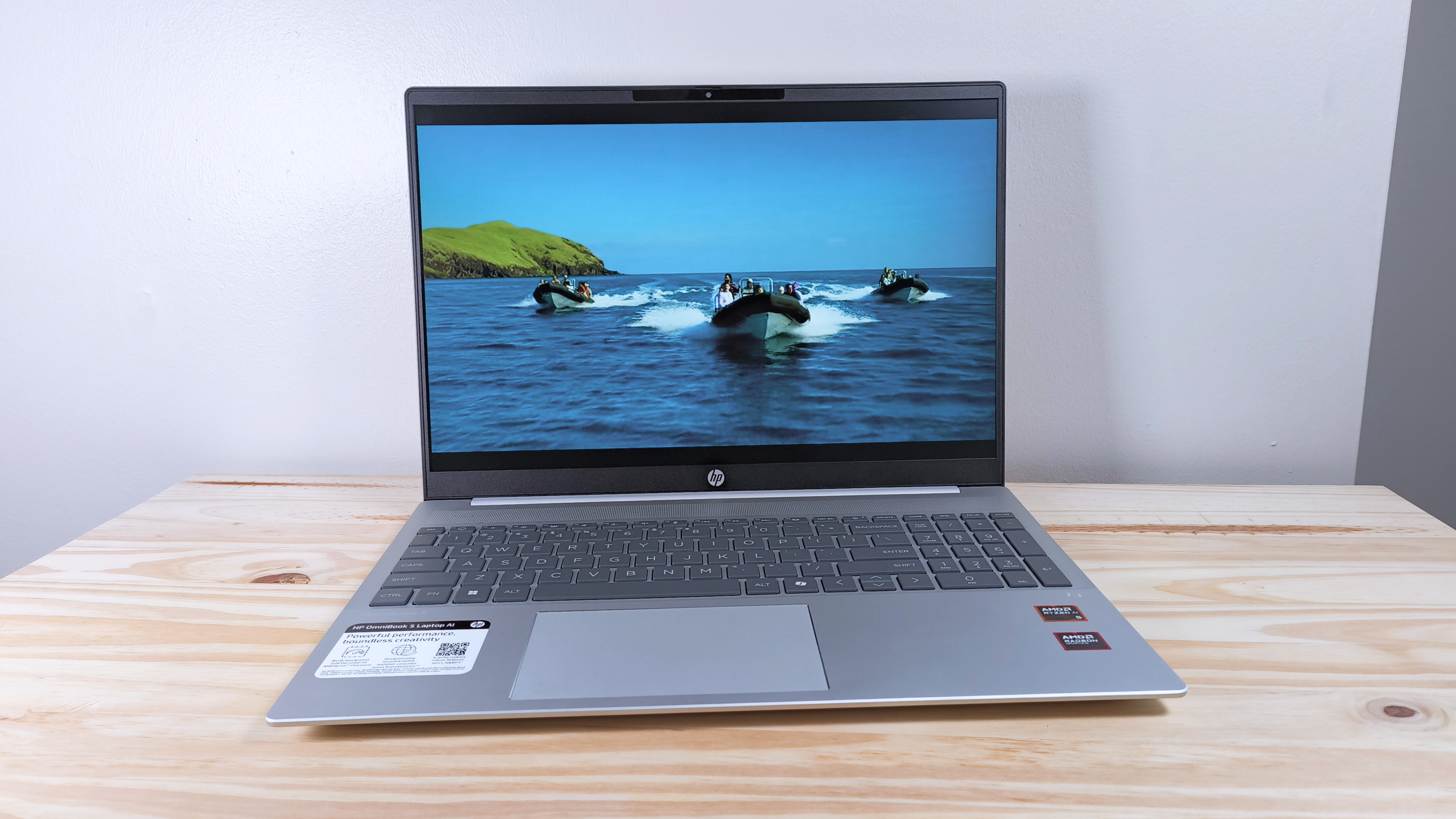 The HP Omnibook 5 Laptop AI on a wood table playing an episode of "Survivor 48" (CBS)