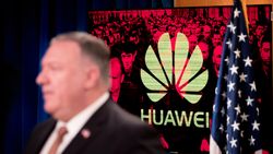 A monitor displays the logo for Huawei behind Mike Pompeo