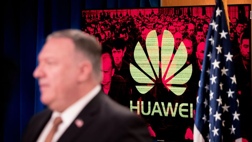 A monitor displays the logo for Huawei behind Mike Pompeo