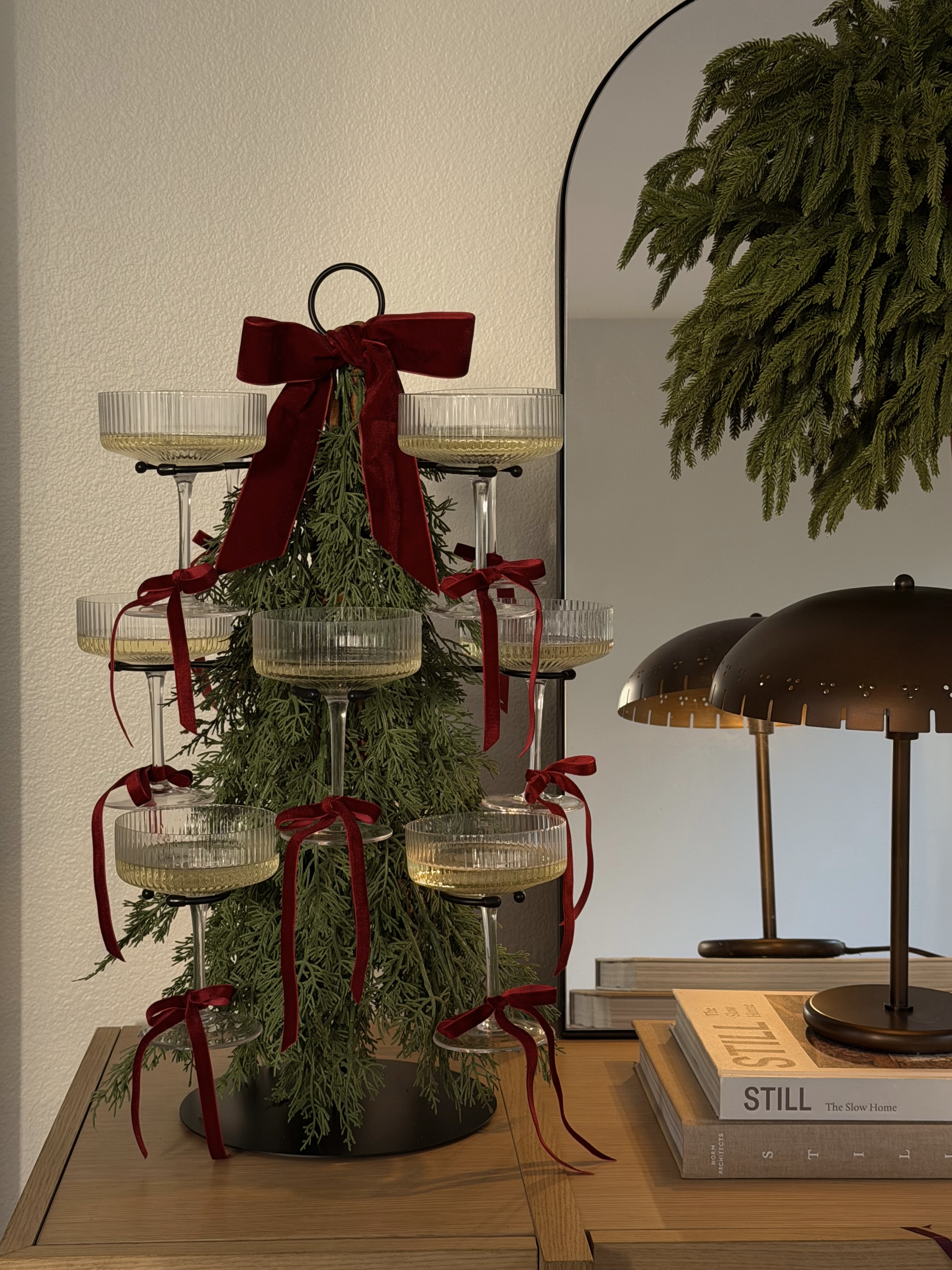 A cocktail stand decorated with pine foliage to look like a Christmas tree