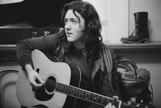 Irish singer and guitarist Rory Gallagher (1948-1995) plays an acoustic guitar backstage prior to a concert at Leeds City Hall in Leeds, England on 25th March 1972.