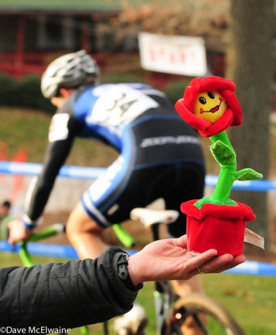A cyclocross fan offers a flower to the racers