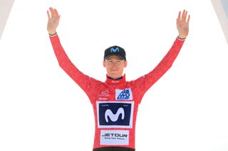 American Matteo Jorgenson (Movistar) on the podium in the race winner's red jersey at the 2023 Tour of Oman