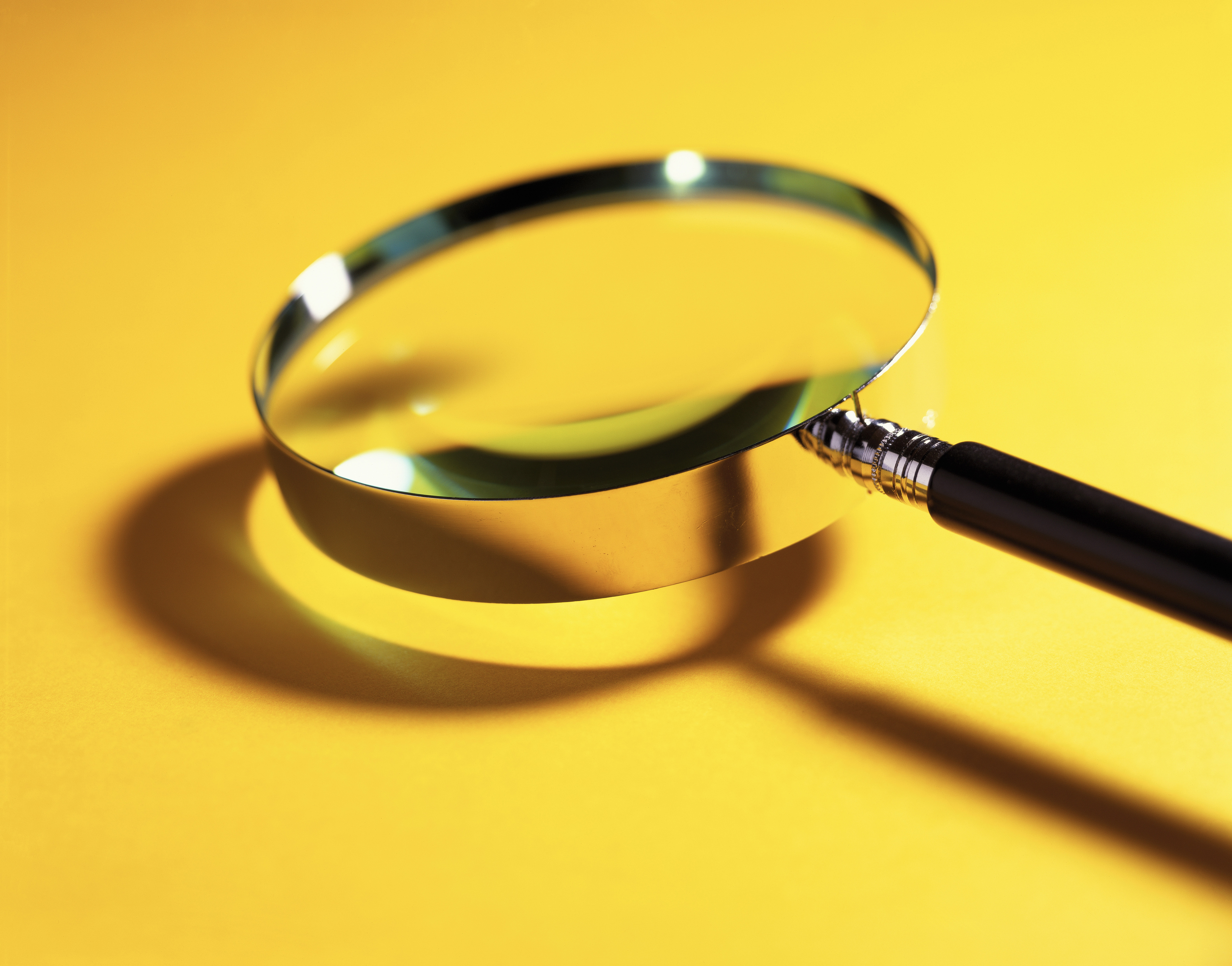 A magnifying glass against a yellow background