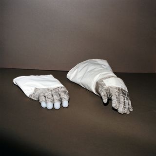 Two large white gloves with silver metallic looking fingers.