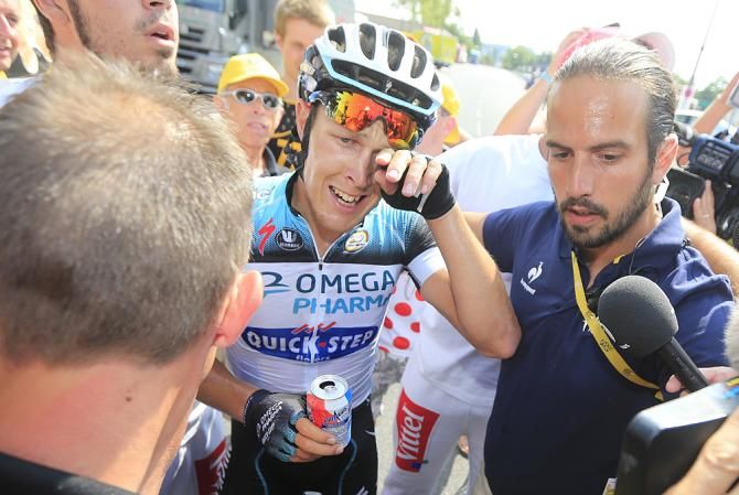 Matteo Trentin (Omega Pharma-Quickstep) is led away to the winner's podium, grinning ear to ear