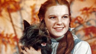 Judy Garland, as character Dorothy Gale, holds Toto in a publicity still for "The Wizard of Oz"
