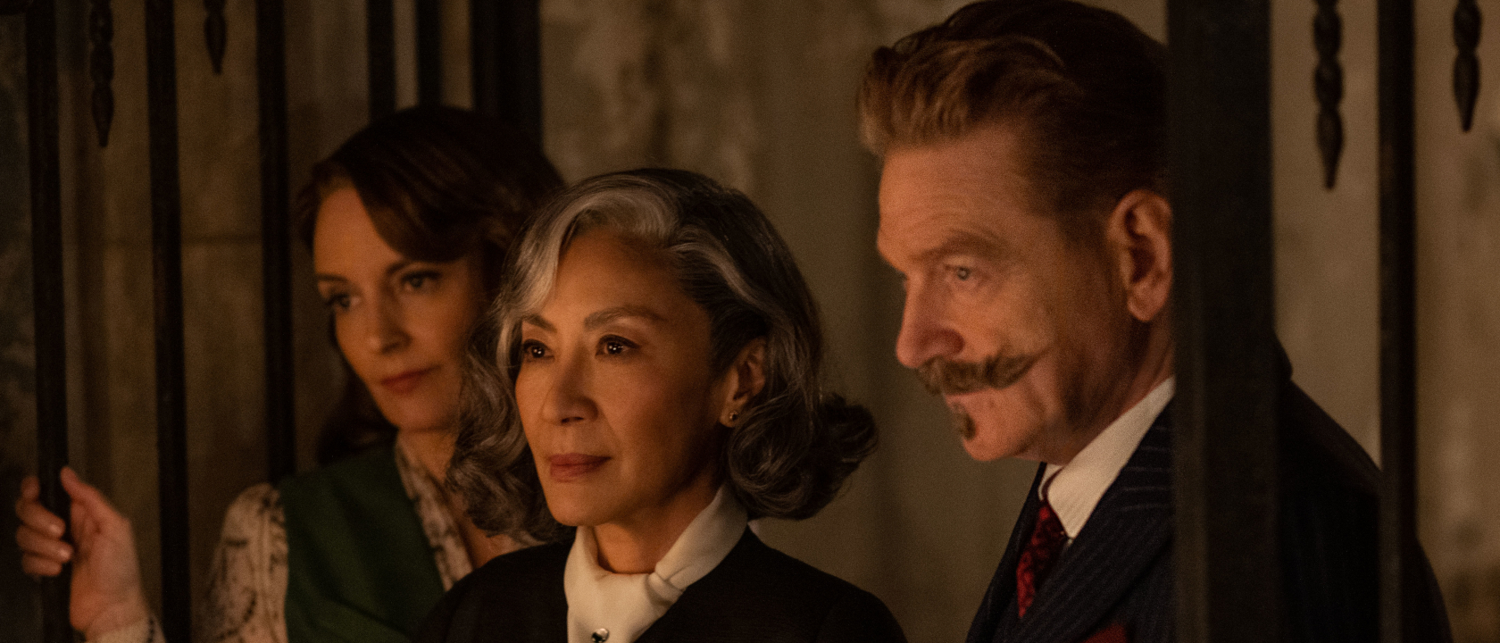 Tina Fey, Michelle Yeoh, and Kenneth Branagh entering a room together in A Haunting in Venice's palazzo.