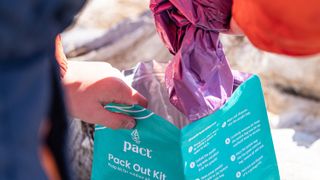 Hiker using a PACT Outdoors pack out kit