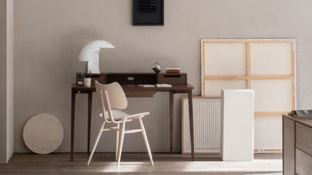 A small desk in dark wood in a modern living soace