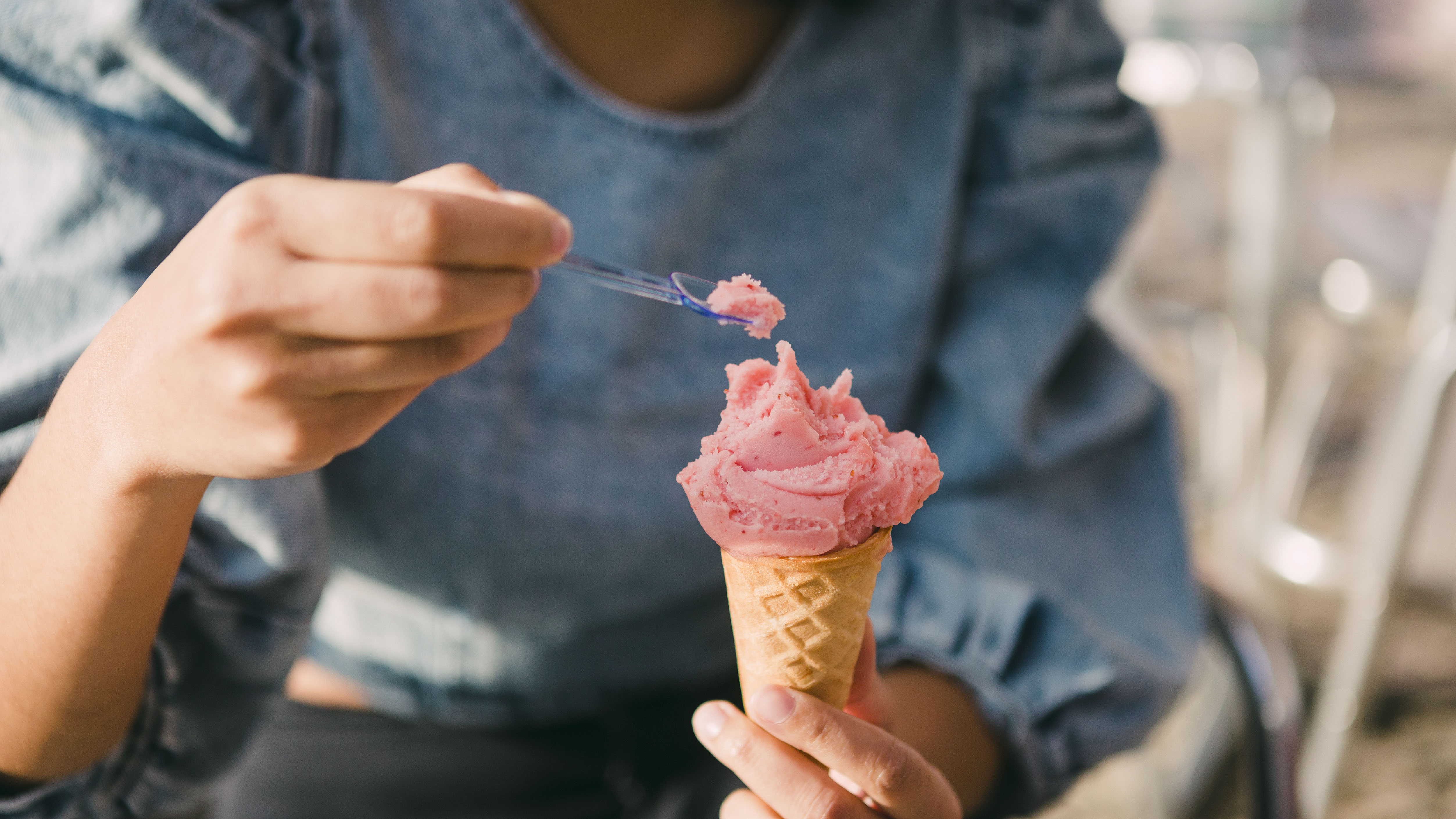 Mujer comiendo helado rosa