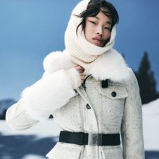 Woman wearing Mytheresa winter coat with snow mountains in background