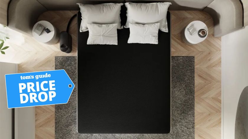 Birds eye view of black Eight Sleep pod 4 smart mattress cover with white pillows in bedroom with wooden herringbone floor and grey rug