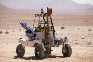 The rover in its mobile configuration with drill raised and visible at the front, arm stowed, and instruments closed.