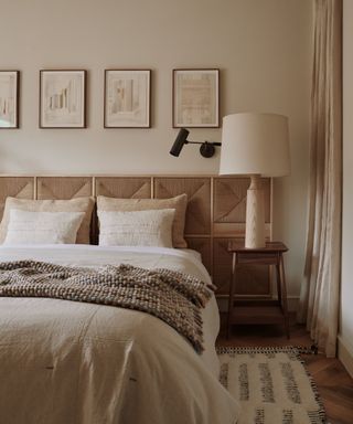 A neutral, textured bedroom with artwork above the bed and an embroidered headboard