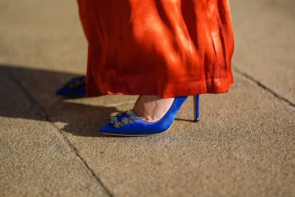 PARIS FRANCE NOVEMBER 29 Alba Garavito Torre wears red empire satin high waist and wide legs trousers palazzo pants from Yseult royal blue satin pumps heels shoes with a silver buckle on the toe cap pumps heels shoes form Manolo Blahnik during a street style fashion photo session on November 29 2021 in Paris France Photo by Edward BerthelotGetty Images