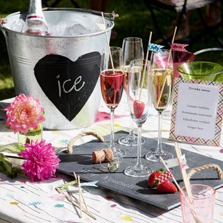 Champagne glasses on slate tray beside menu and ice bucket