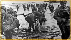 A black and white photo of soldiers in World War II uniforms walking up a beach. 