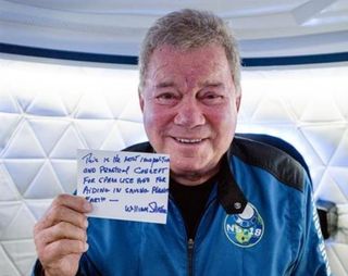Actor William Shatner holds up a postcard he wrote for Blue Origin's Club For The Future that will fly in space on his New Shepard rocket.