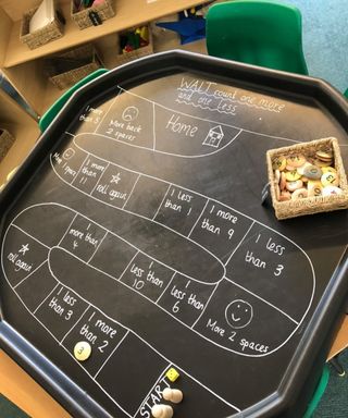 A black board game tuff tray that uses chalk
