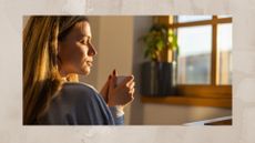 Woman drinking coffee at home during sunrise