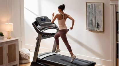 Person running on a NordicTrack Commercial 1750 folding treadmill in a living room