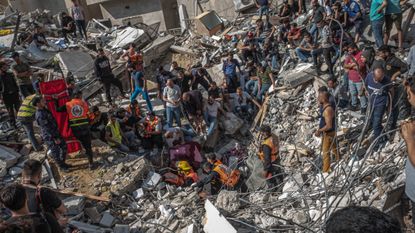 Palestinians search for bodies in the rubble of a bombed building