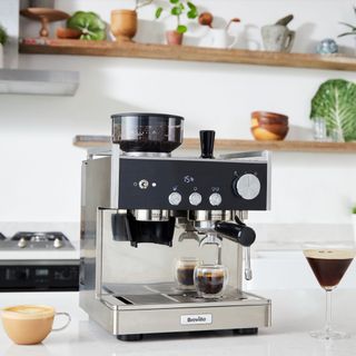 The Breville Barista Signature Espresso Machine with an espresso martini next to it