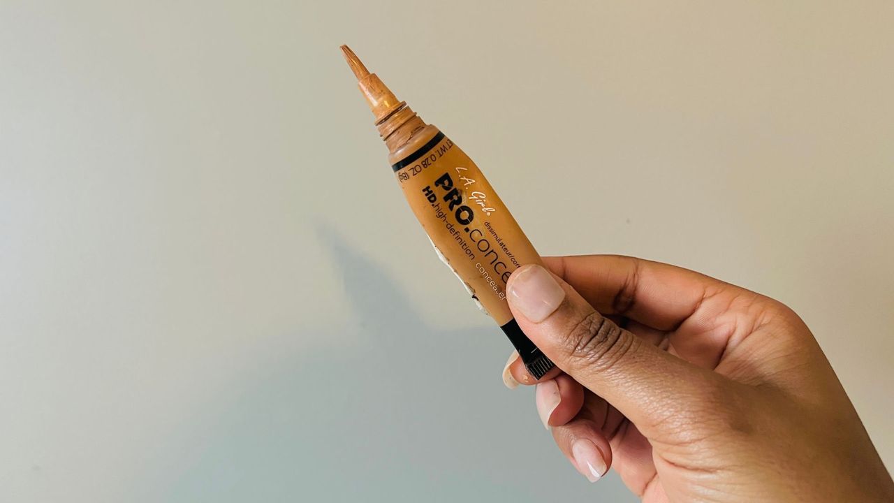 A person holding an opened L.A. Girl HD Pro Concealer for the best drugstore concealers.