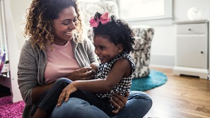 A woman who agreed to be a guardian in a trust sits with a child on her lap.