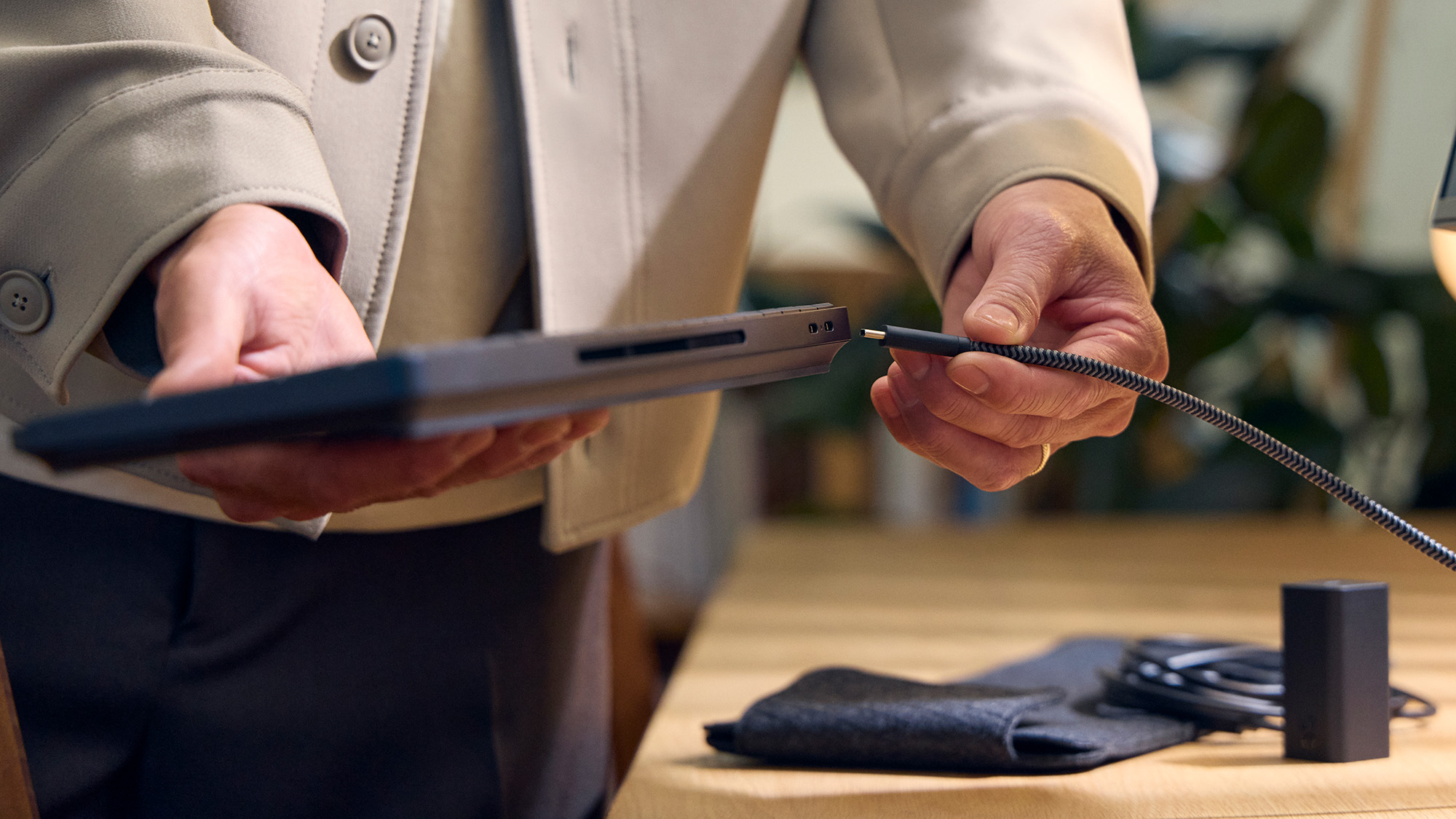 HP EliteBoard G1a Next Gen AI PC with a detachable USB-C cable held in hand