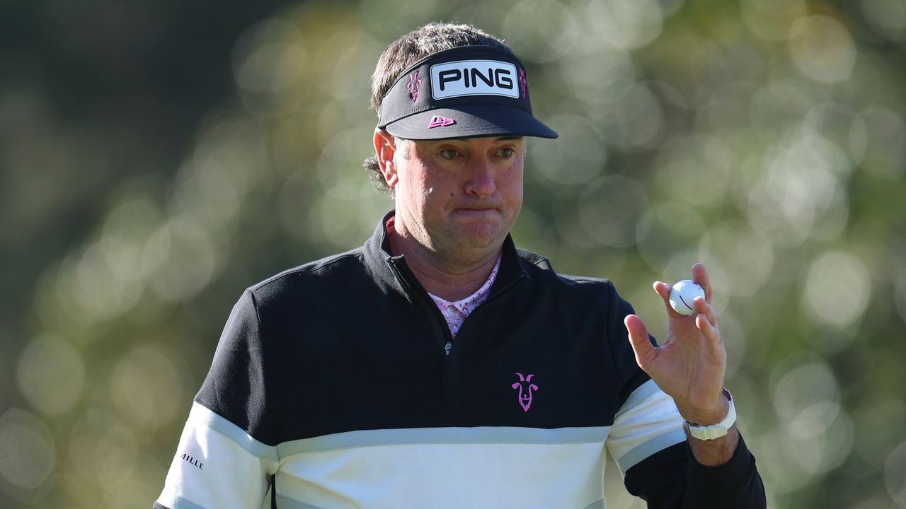 Bubba Watson waves to the crowd after holing a putt