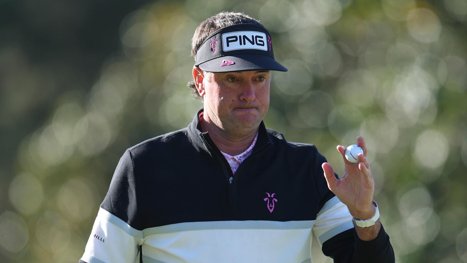 Bubba Watson waves to the crowd after holing a putt