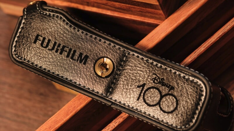 Disney-themed Fujifilm X100V camera leather half-case on a wooden table