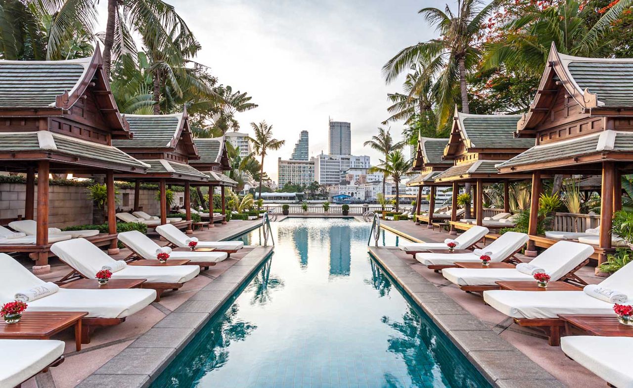 Sun loungers surround the swimming pool with views of the city in the distance