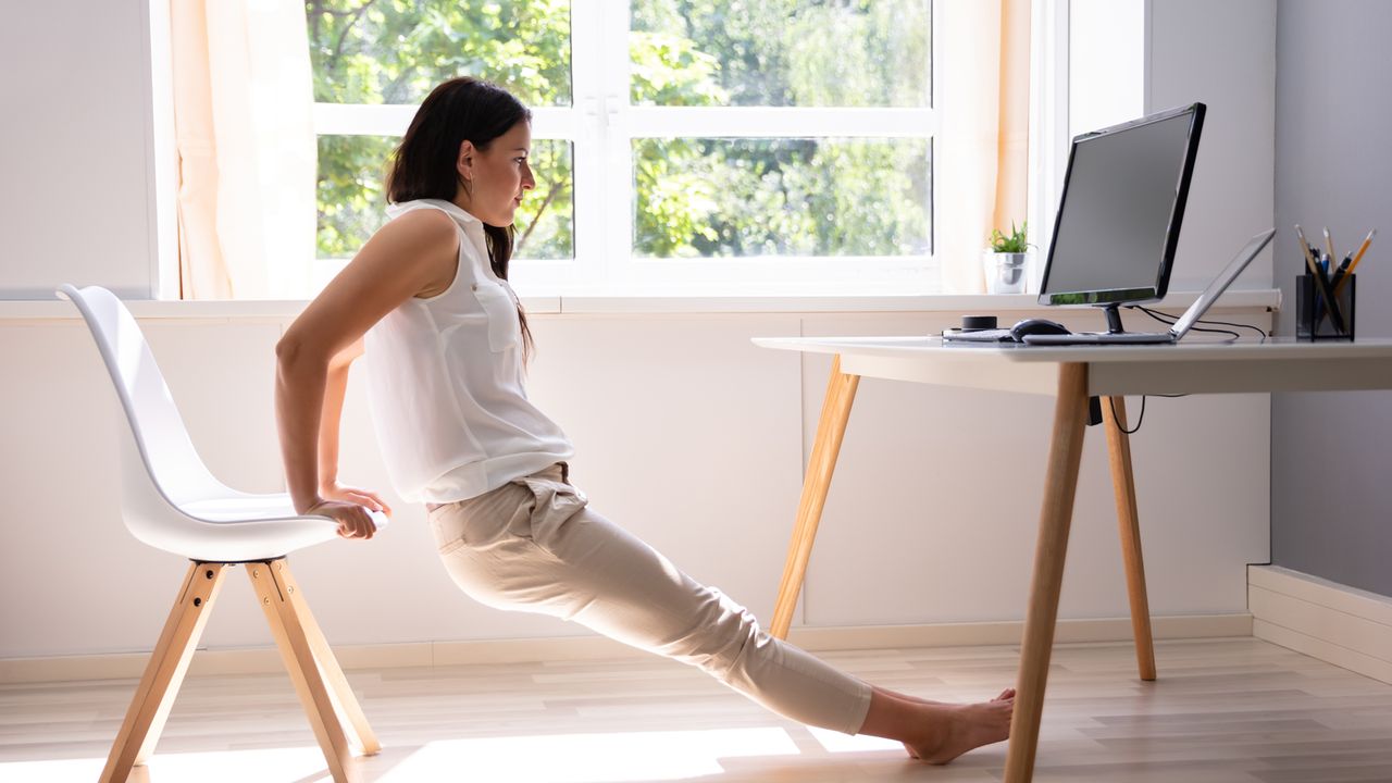 Woman works out at her work desk