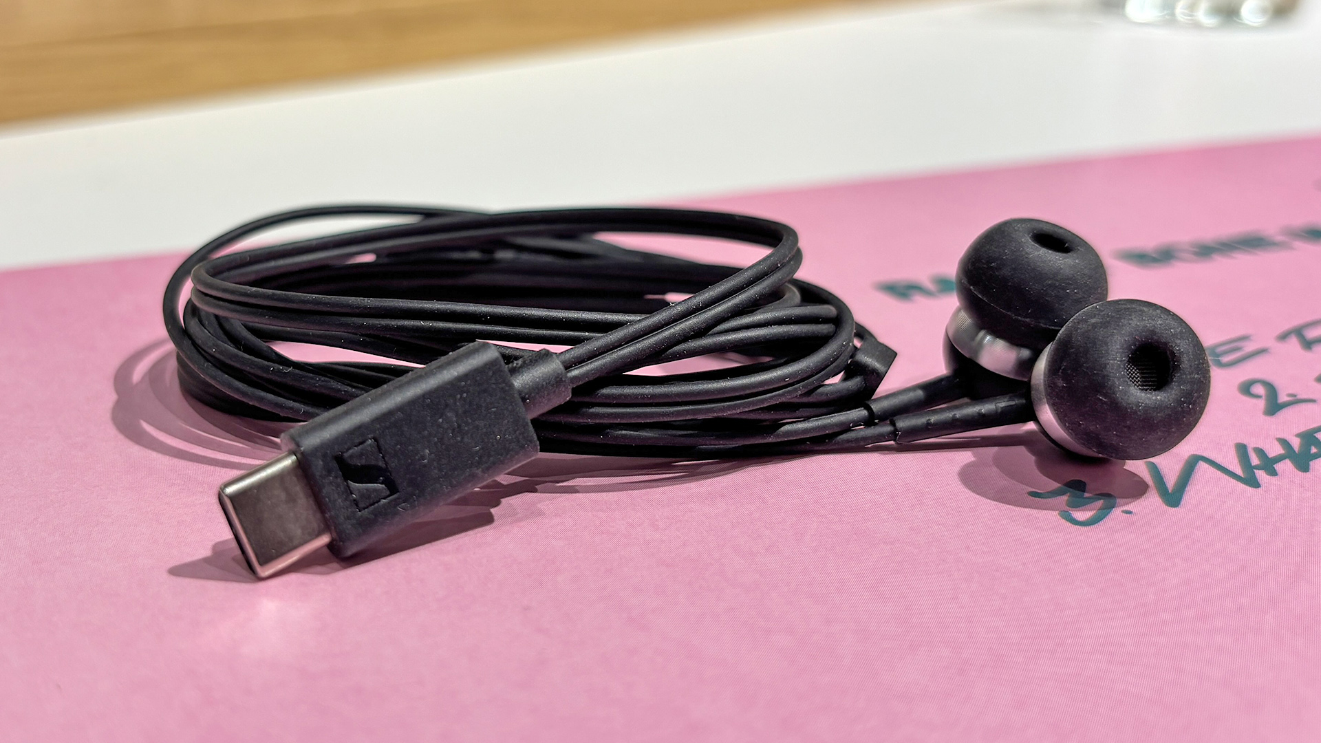 Sennheiser CX 80U wired earbuds coiled up on pink album cover