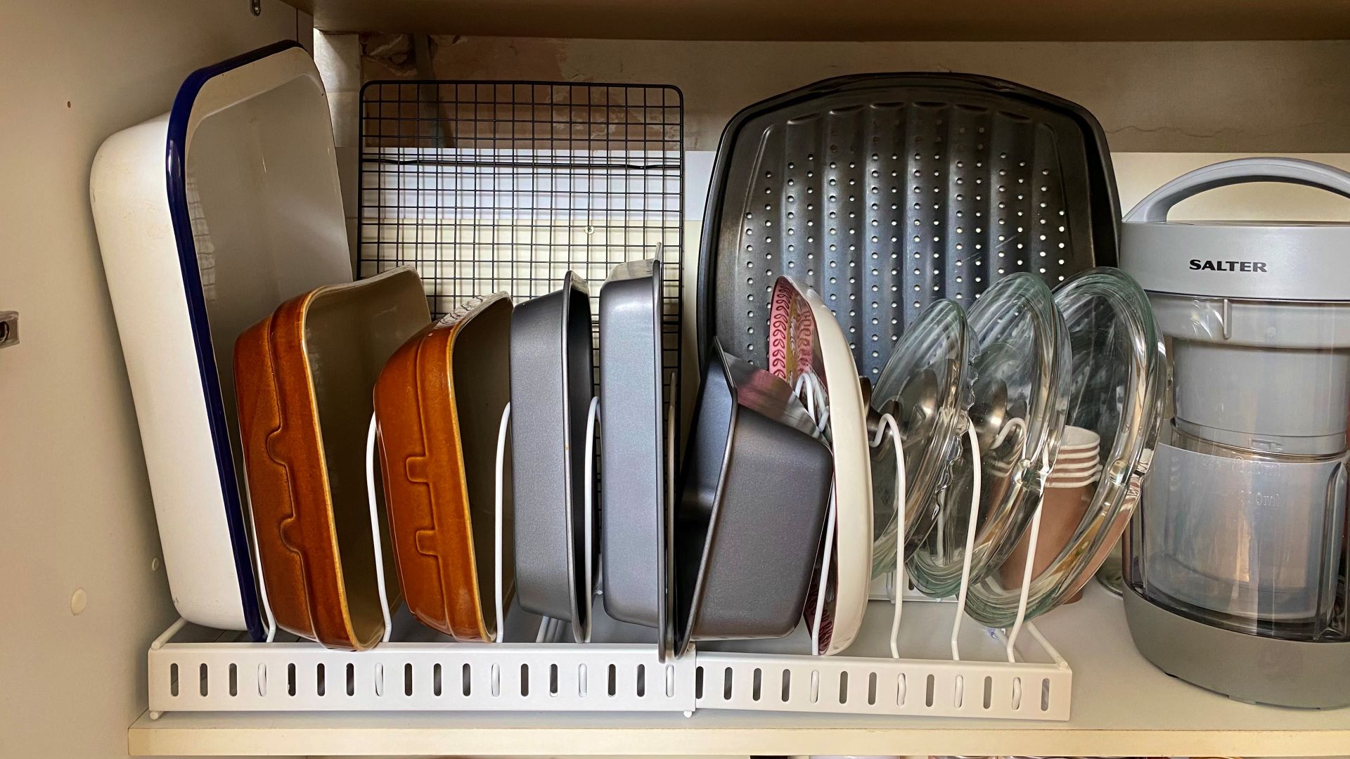 bakeware and pan lids stored on rack